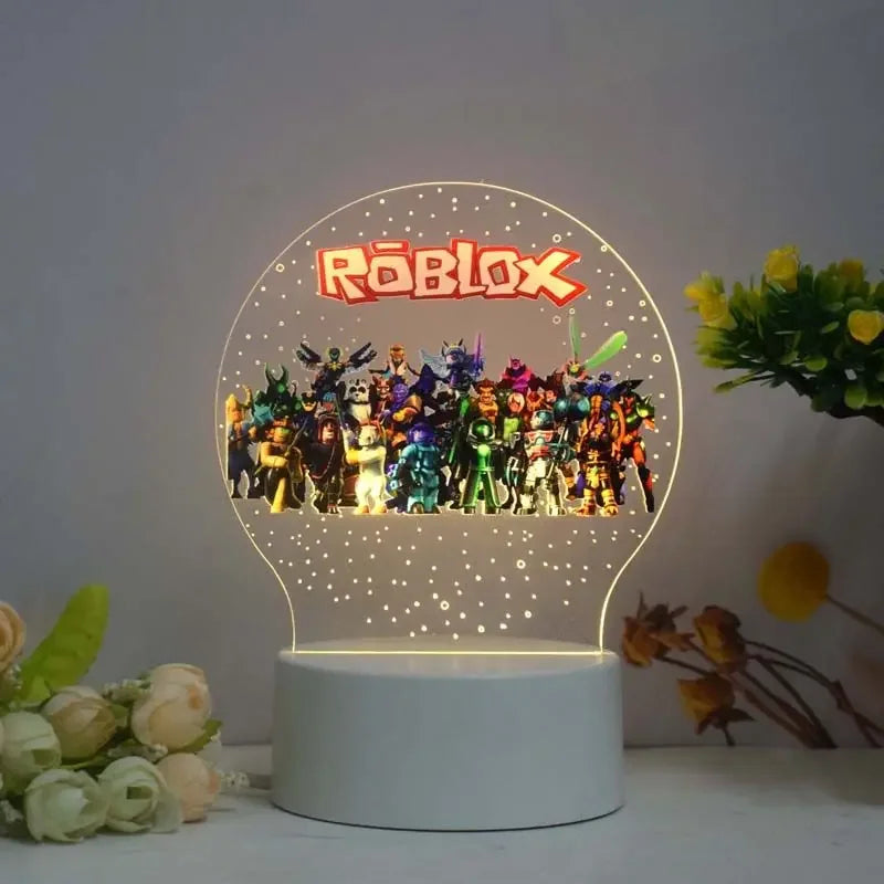 Roblox-themed night light with colorful characters on a white base, surrounded by flowers.