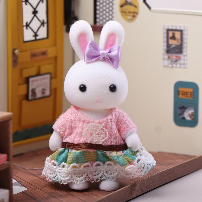 Plush toy rabbit in a pink dress with a bow on a wooden surface.