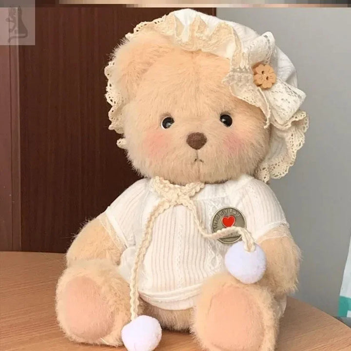 Teddy bear wearing a white outfit with a heart emblem on a wooden surface.
