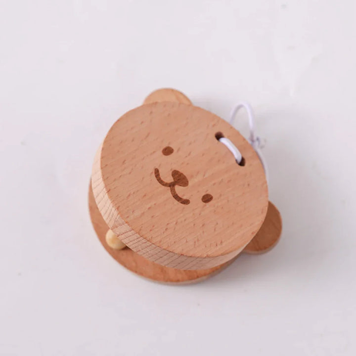 Small round wooden toy with a face on a white background.