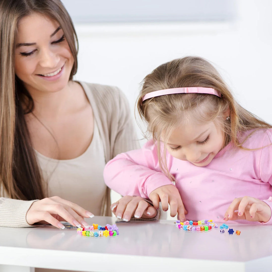 Woman and young girl playing with colorful beads at a table.