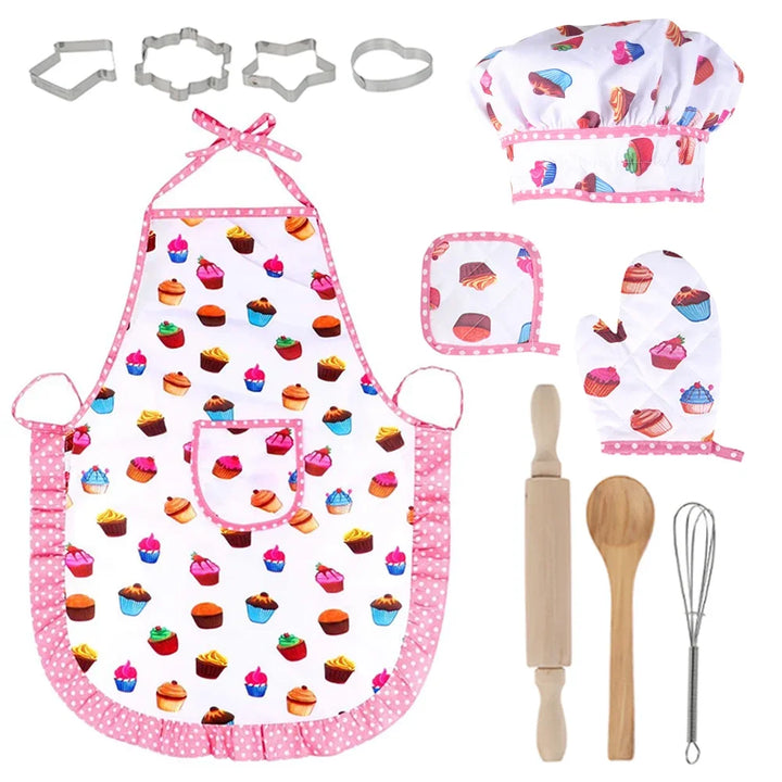 Children's baking set with apron, hat, oven mitts, cookie cutters, rolling pin, wooden spoon, and whisk on a white background.
