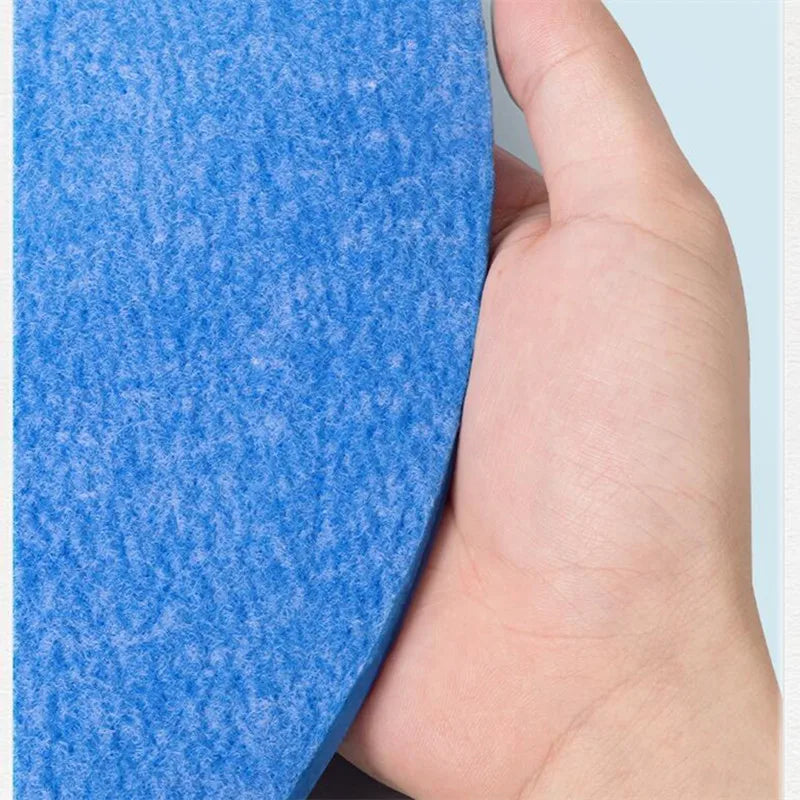 Hand holding a blue textured object against a light blue background.