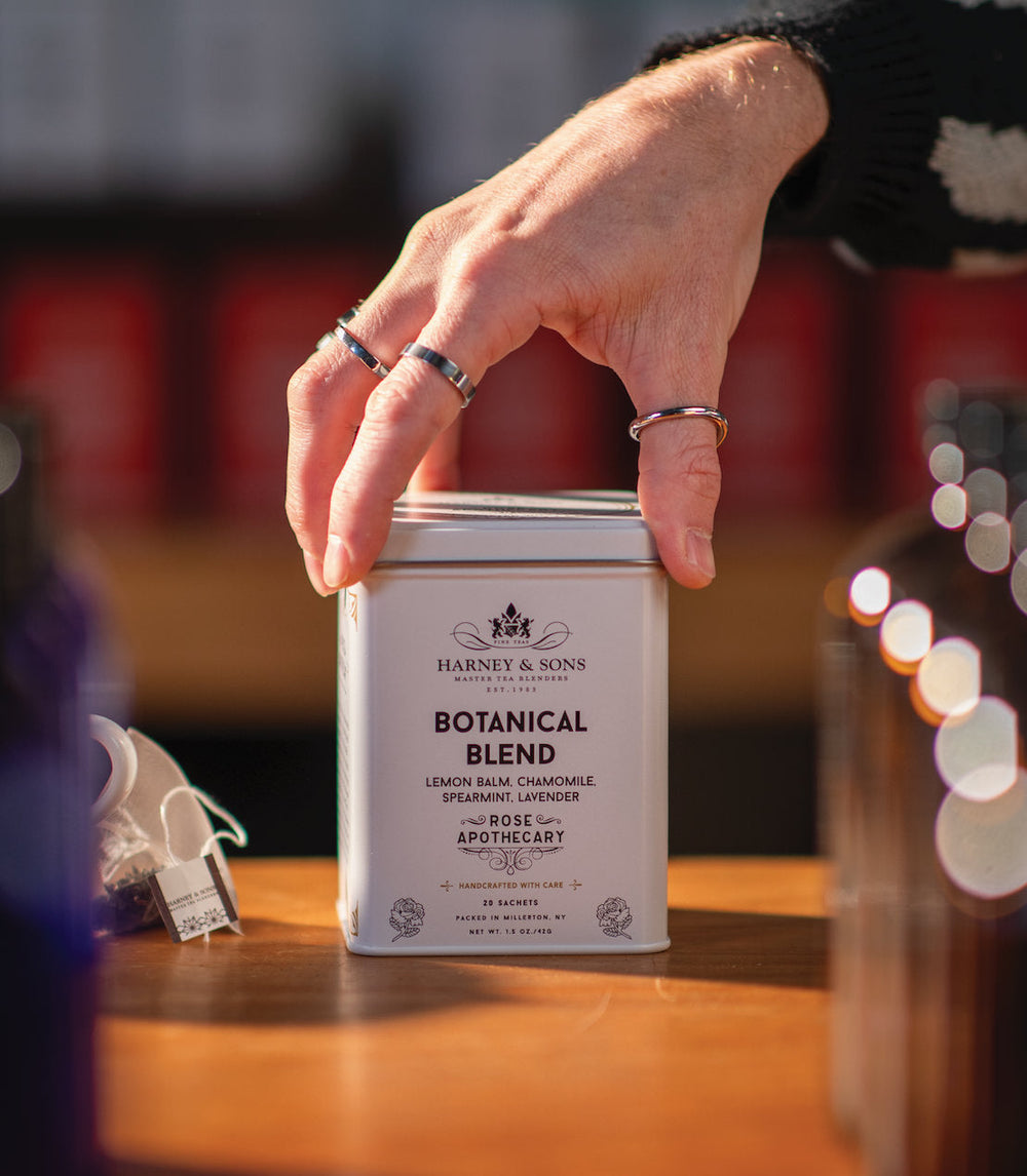 Botanical Blend Tea Tin of 20 Sachets with hand holding it.