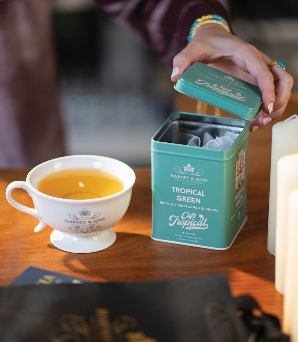 Teacup with Harney and Sons Tropical Green tea on a wooden table.