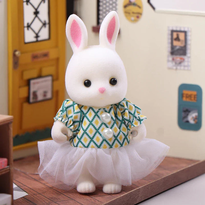 White rabbit plush toy with a green and yellow patterned dress on a miniature room background.
