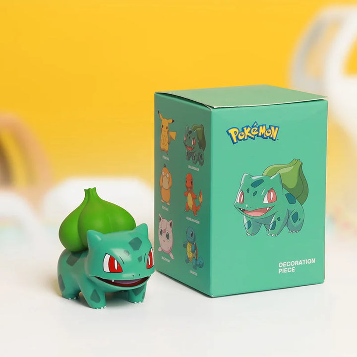 Pokémon Bulbasaur figurine next to its packaging on a yellow background.