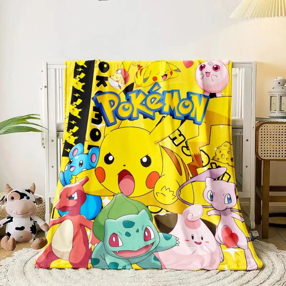 Pokémon-themed blanket with characters on a bed.