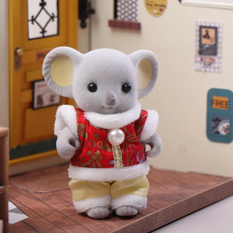 Plush toy koala in a red outfit standing on a wooden floor.