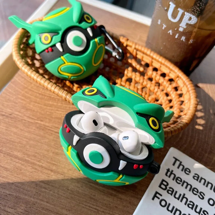 Green and black cartoon-style case for wireless earbuds on a wooden surface with a blurred background.