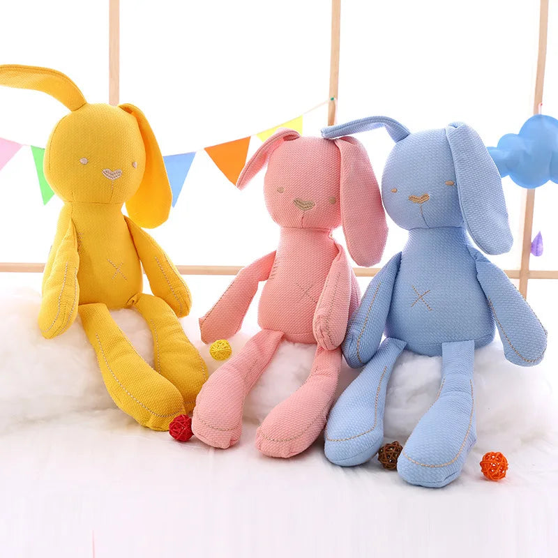 Three colorful plush toys resembling bunnies on a white background with small flags.