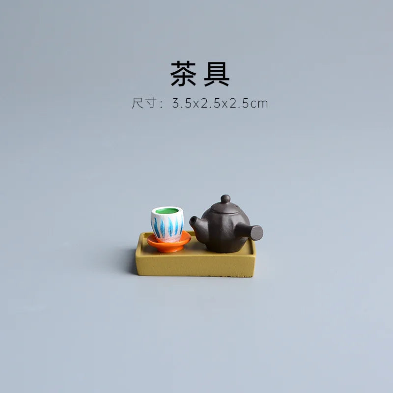 Tea set with a teapot and cup on a small yellow platform against a gray background.