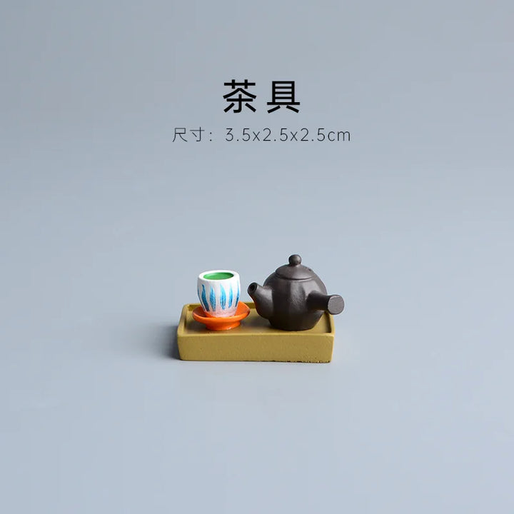 Tea set with a teapot and cup on a small yellow platform against a gray background.