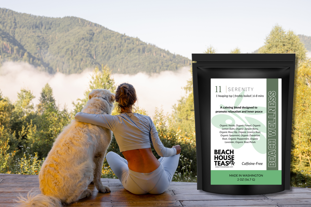 Person sitting with a dog on a wooden deck with a scenic background, next to a package of Beach House Teas.