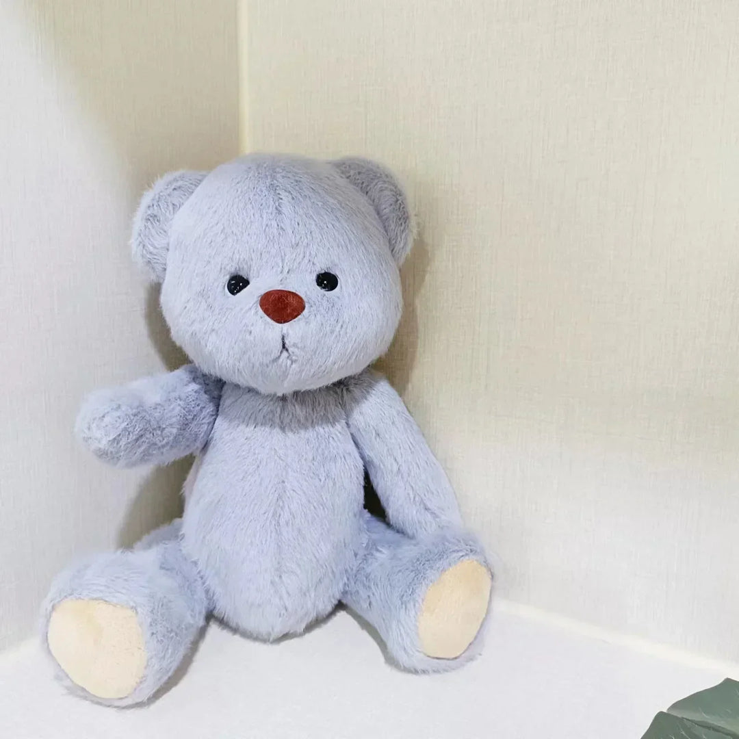 Gray teddy bear with a red nose on a white background.