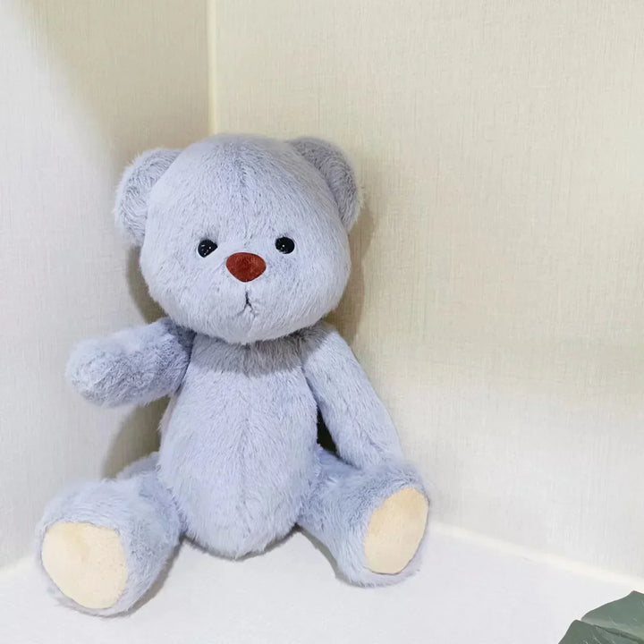 Gray teddy bear with a red nose on a white background.