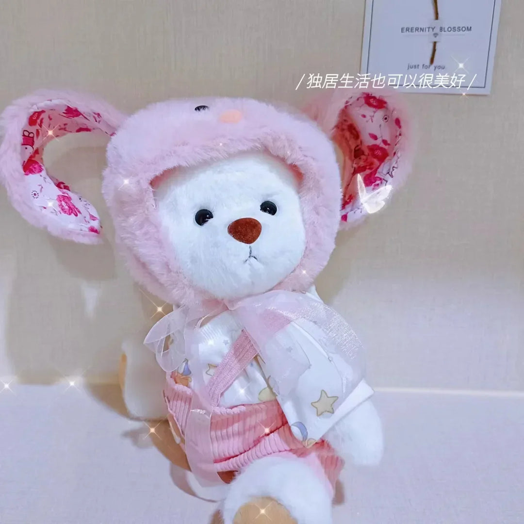 Plush toy with pink floral hat and outfit on a light background.