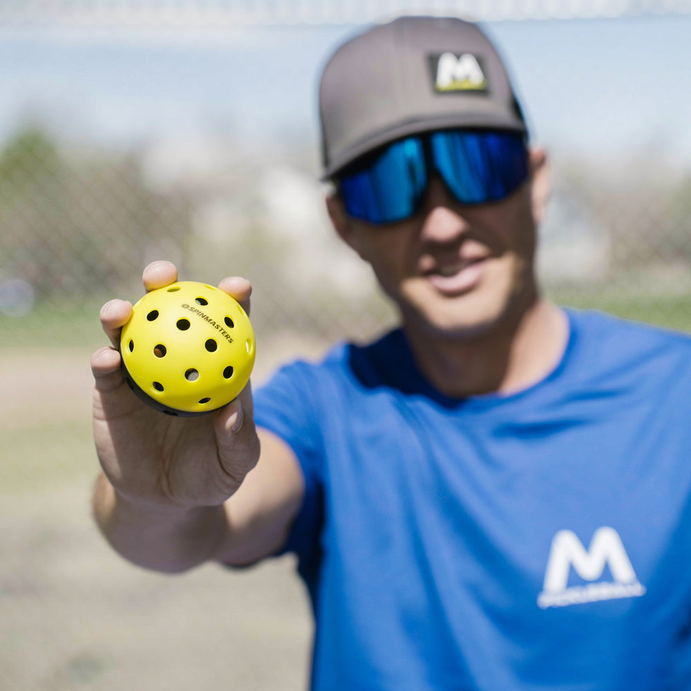 Moment Spinmasters 2-Color Indoor/Outdoor Balls for Pickleball Training in Hand.