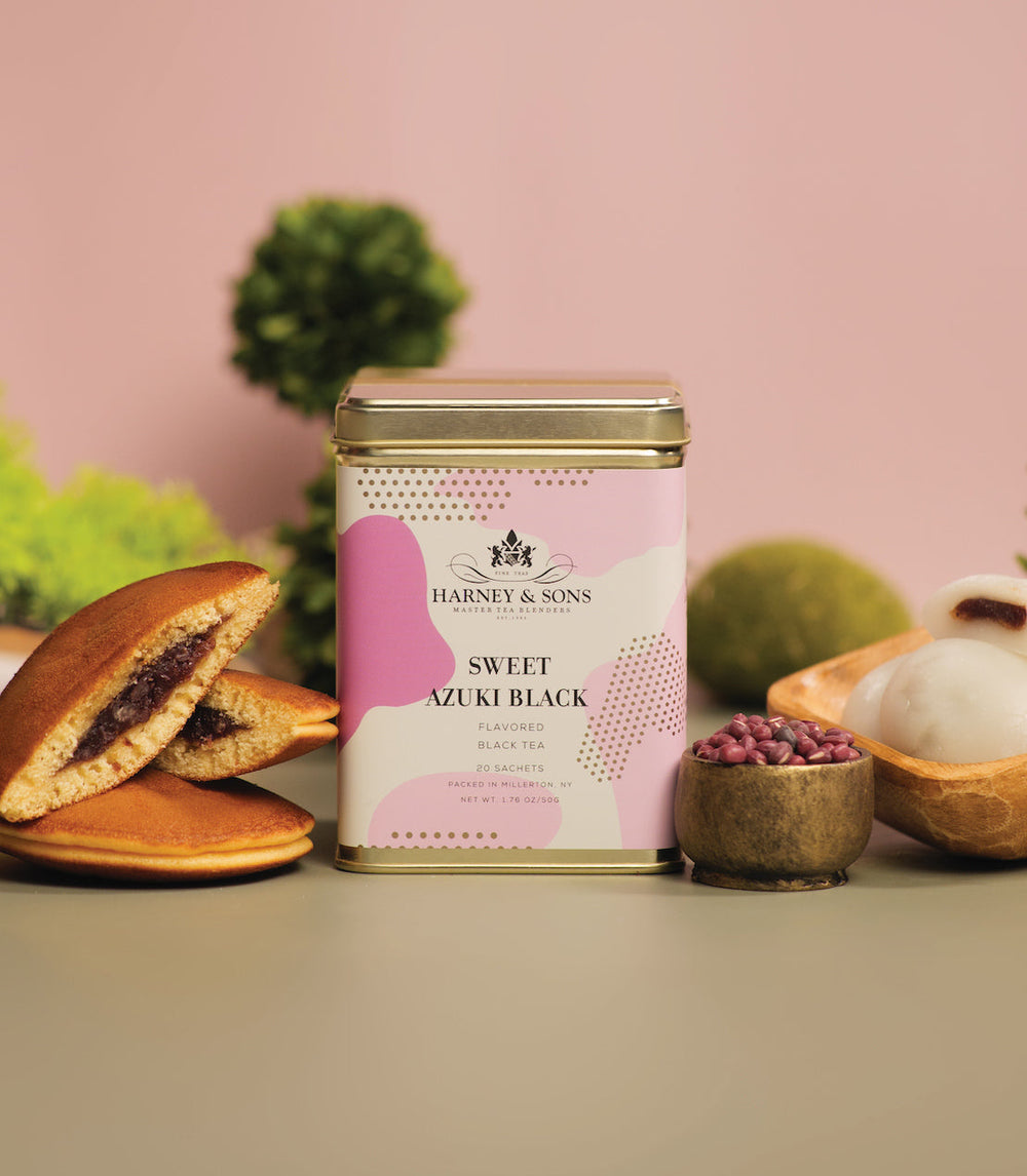 Harney and Sons Sweet Azuki Black tea canister with traditional Japanese pastries and beans on a pink background.