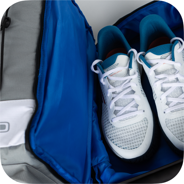 White sneakers inside an open blue and gray bag.