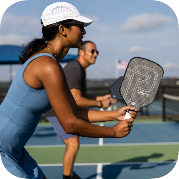 Woman playing pickleball on a court with a blurred background.
