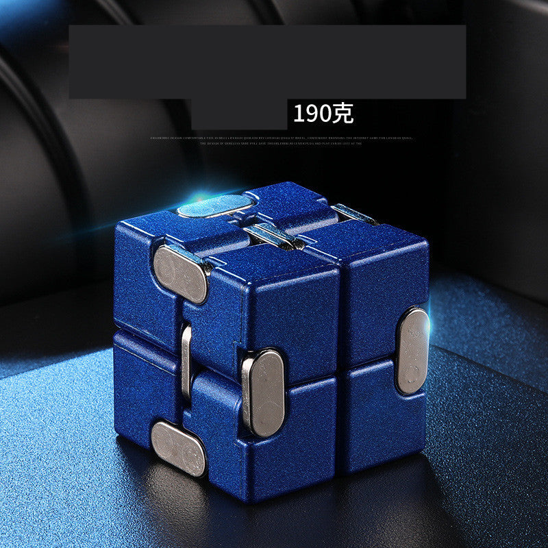 Blue fidget cube with metallic accents on a reflective surface.