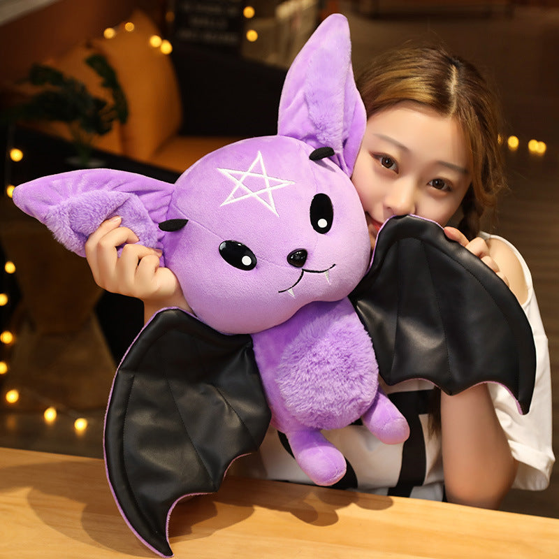 Person holding a purple plush bat toy with a star design.