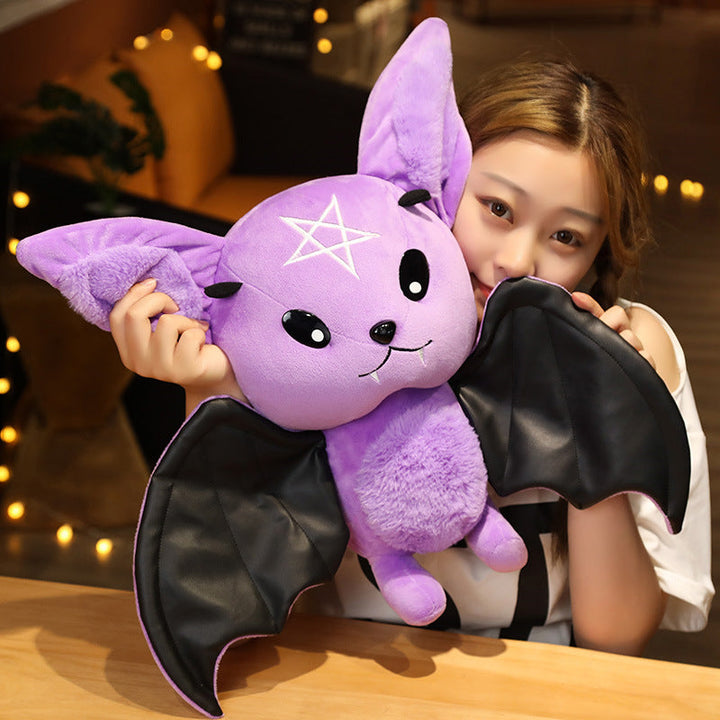 Person holding a purple plush bat toy with a star design.