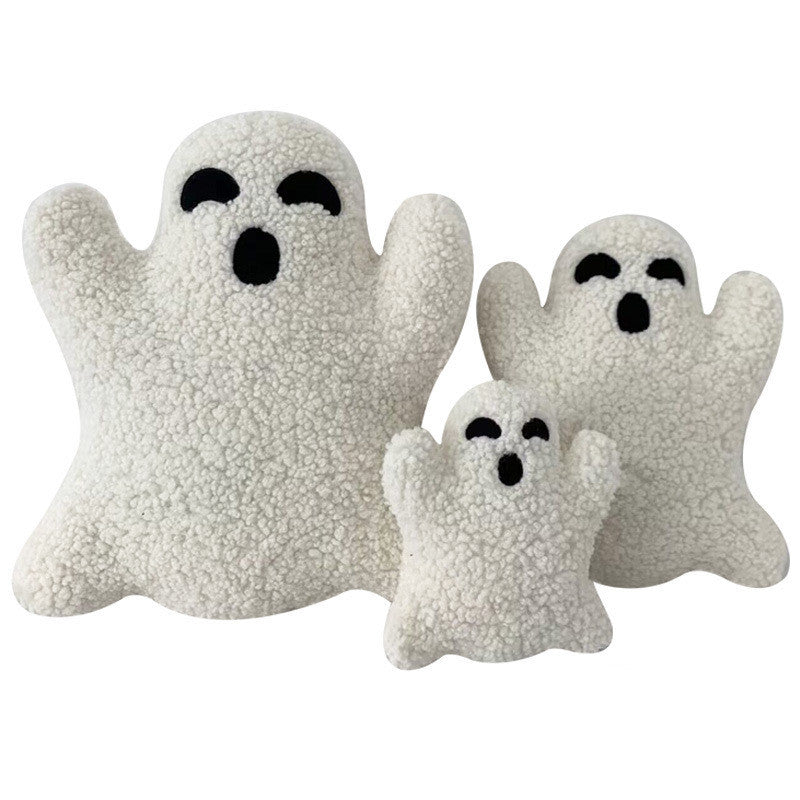 Three white ghost-shaped cushions with black eyes on a white background.