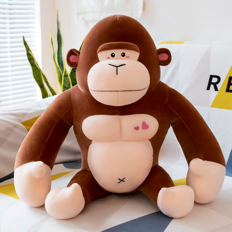 Plush monkey toy with pink cheeks and heart on belly sitting on a surface.