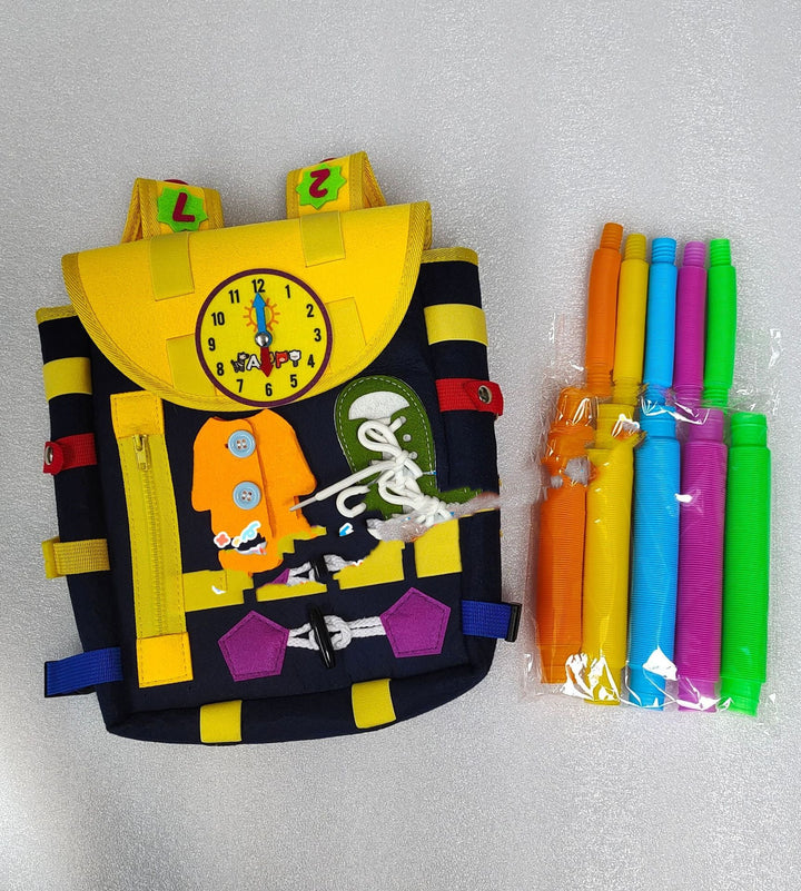 Colorful children's backpack with clock design and packages of straws on a gray background.