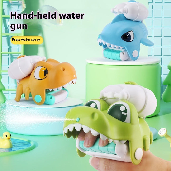 Hand-held water gun toys shaped like a shark, crocodile, and dinosaur on a green background.