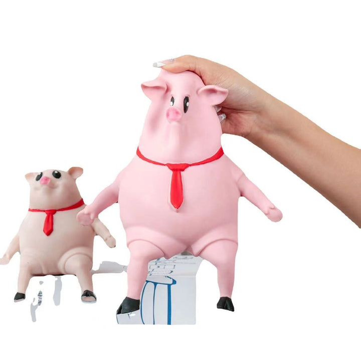 Pink pig plush toy with a hand holding it, on a white background.
