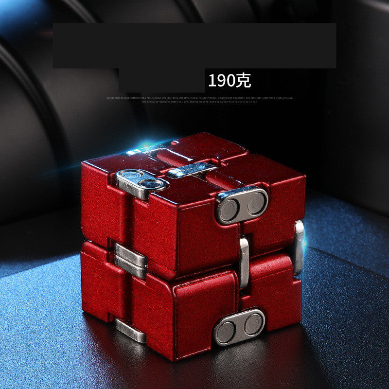 Red and silver cube-shaped object on a dark surface.
