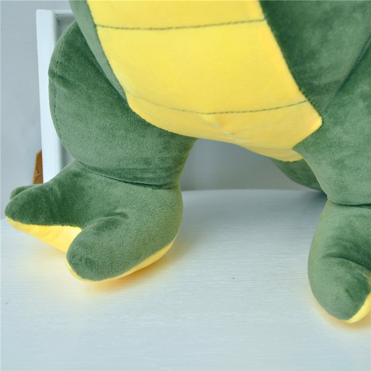 Close-up of a green and yellow plush toy on a white surface.