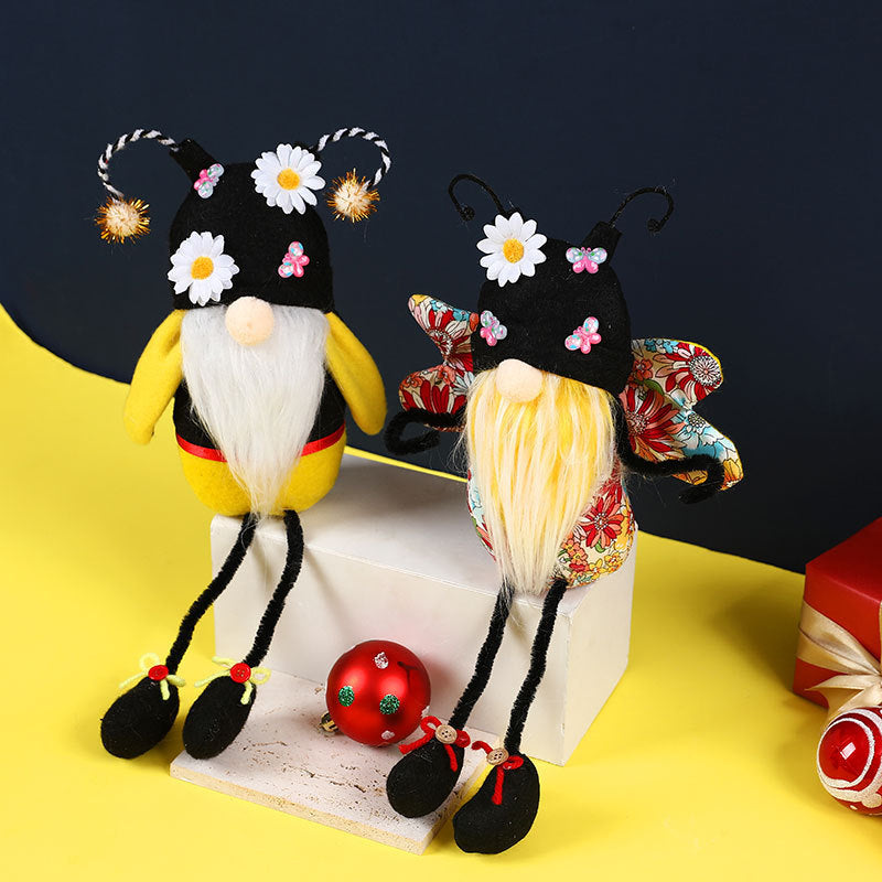 Two decorative figures with floral hats on a yellow surface with a dark background.