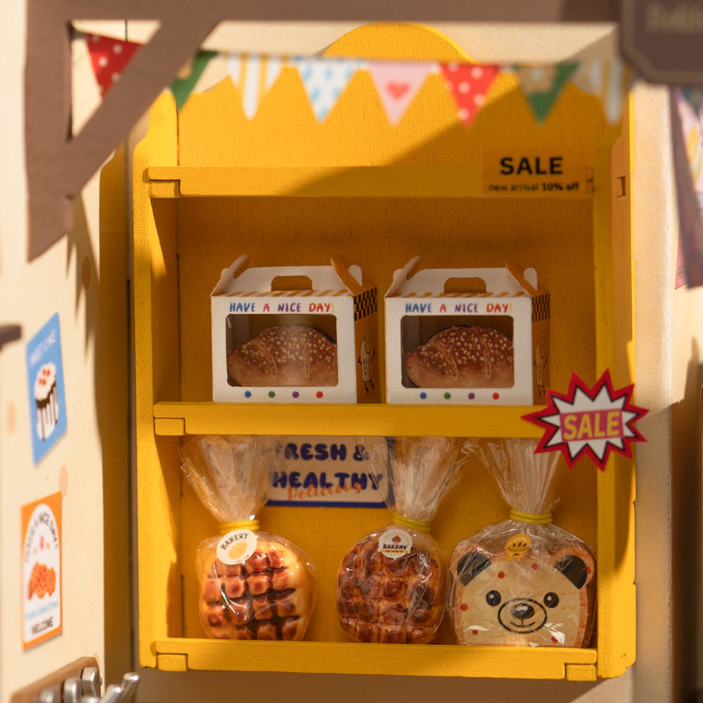 Yellow toy bakery display with bread packages and Have a Nice Day text.