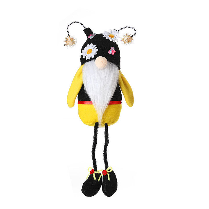 Plush toy resembling a bee with a black and yellow body, white beard, and flower accents on a white background.