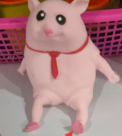 Plush toy pig with a red bow tie on a light background.