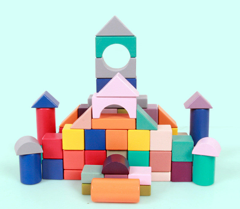 Colorful toy blocks stacked to form a small castle on a light blue background.