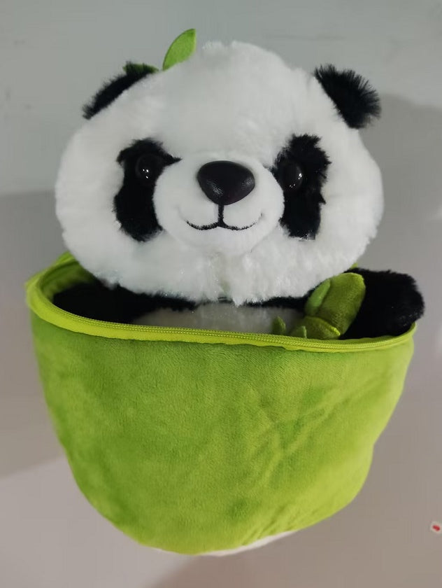 Plush panda toy with a green leaf on a white background.