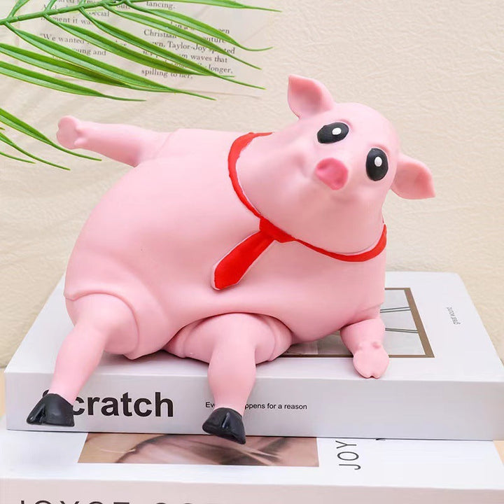 Pink pig figurine with a red collar on a magazine.