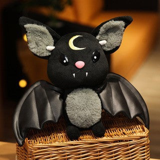 Plush bat toy with a pink nose and white teeth on a blurred background.