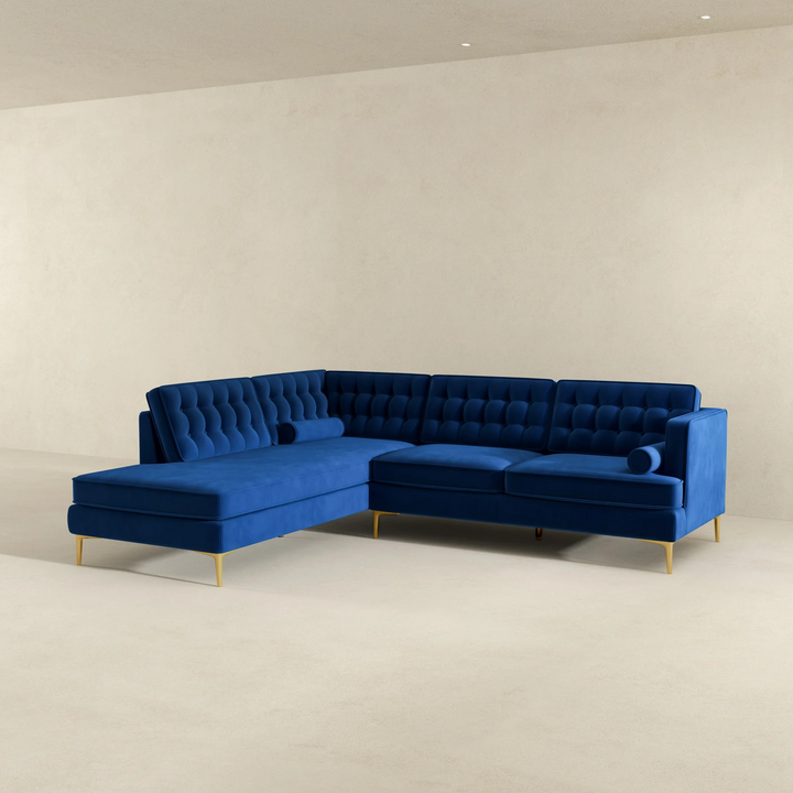 Blue sectional sofa on a beige floor with a plain wall background.