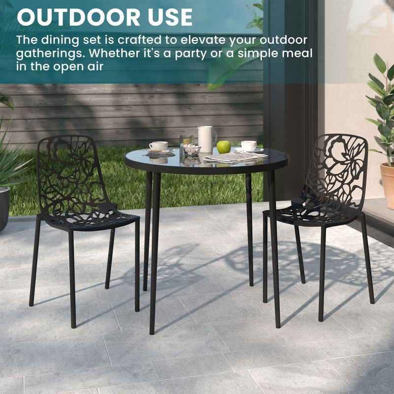 Outdoor dining set with black chairs and table on a patio.