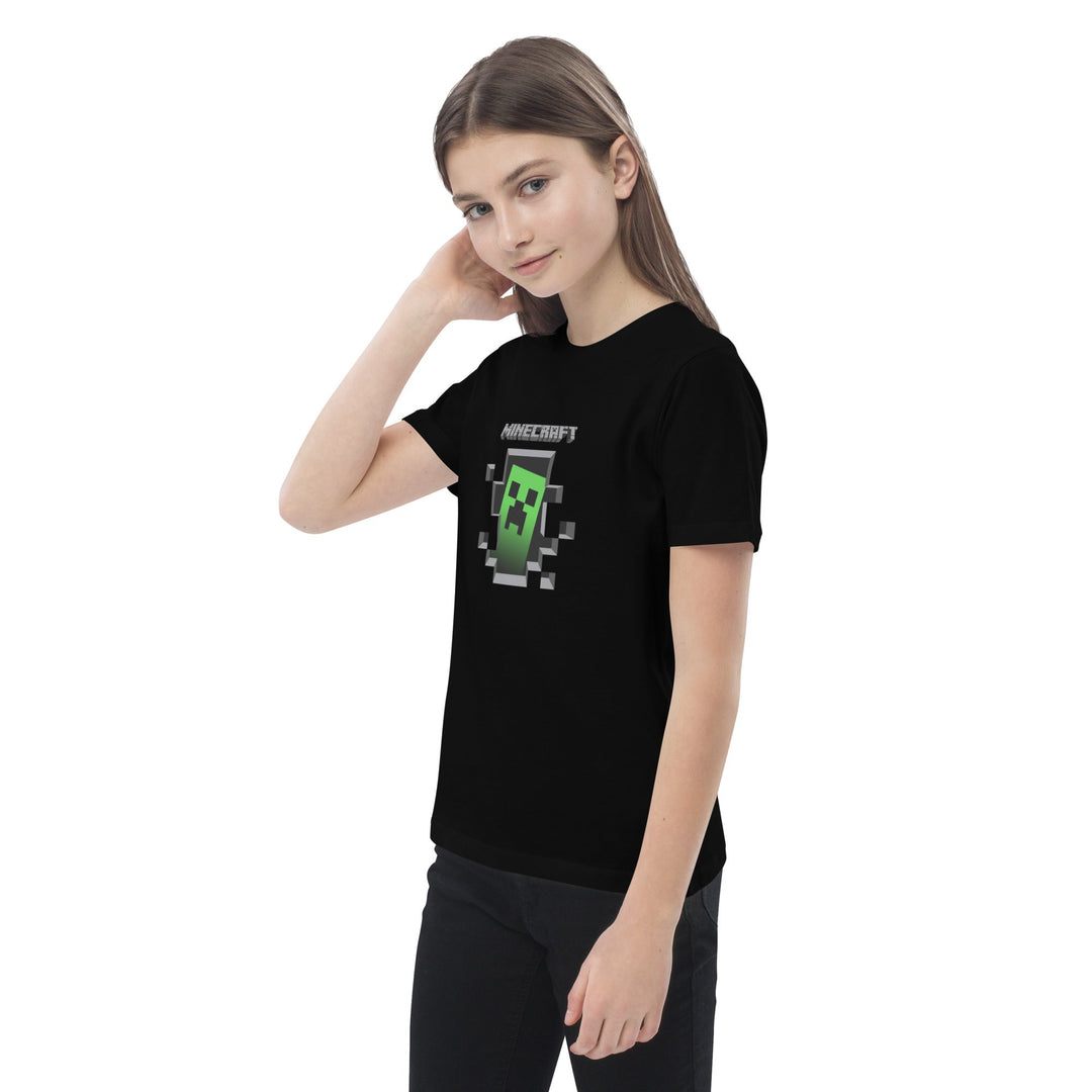 Person wearing a black t-shirt with a Minecraft creeper design on a white background.