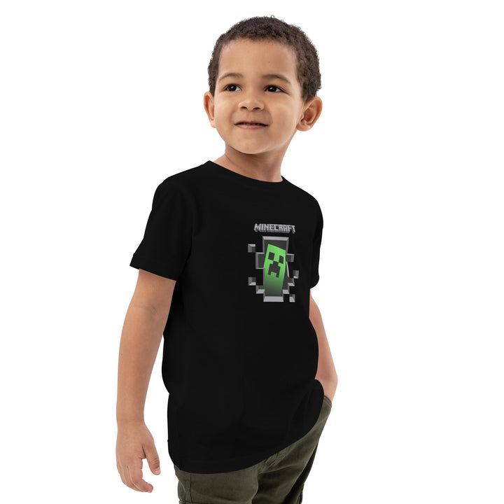 Child wearing a black Minecraft t-shirt with a green character on a white background.