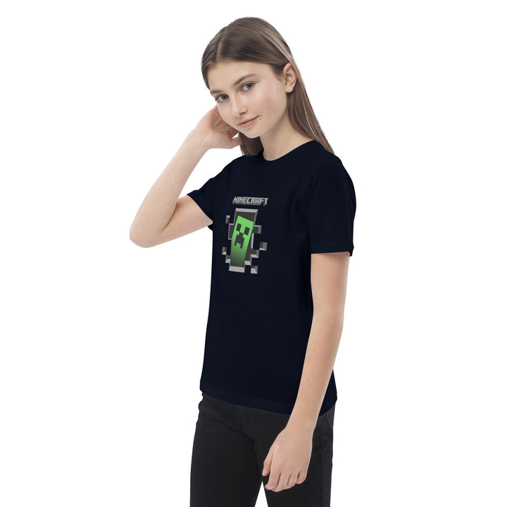 Person wearing a black t-shirt with a Minecraft creeper graphic on a white background.