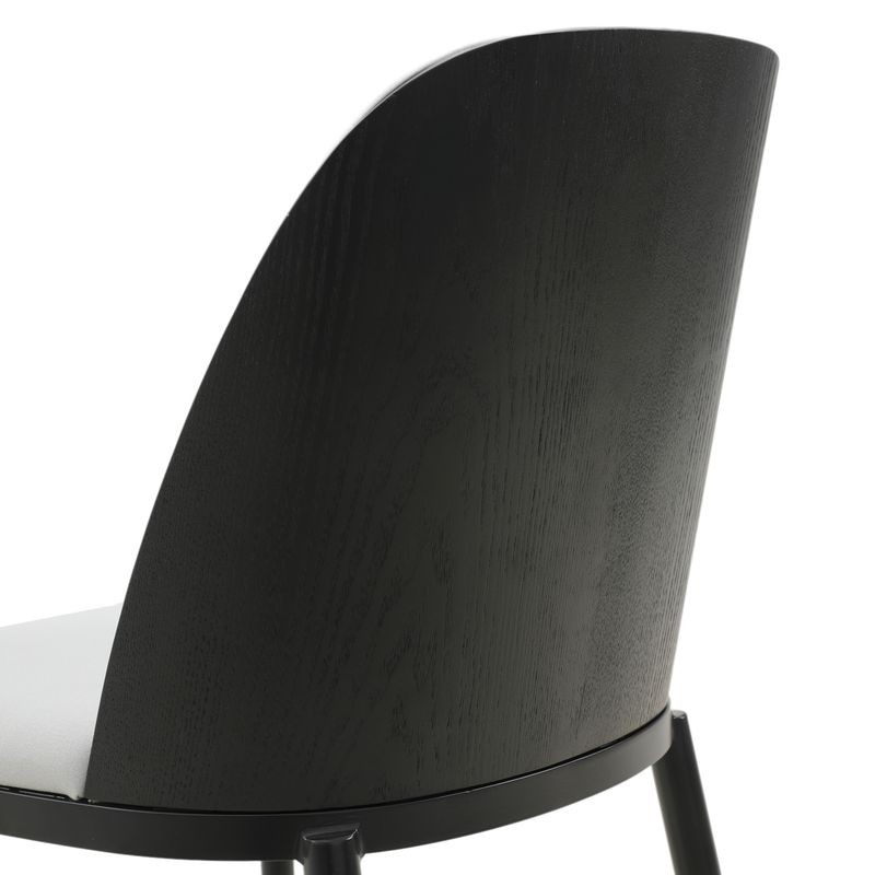 Close-up of a black chair backrest on a white background.