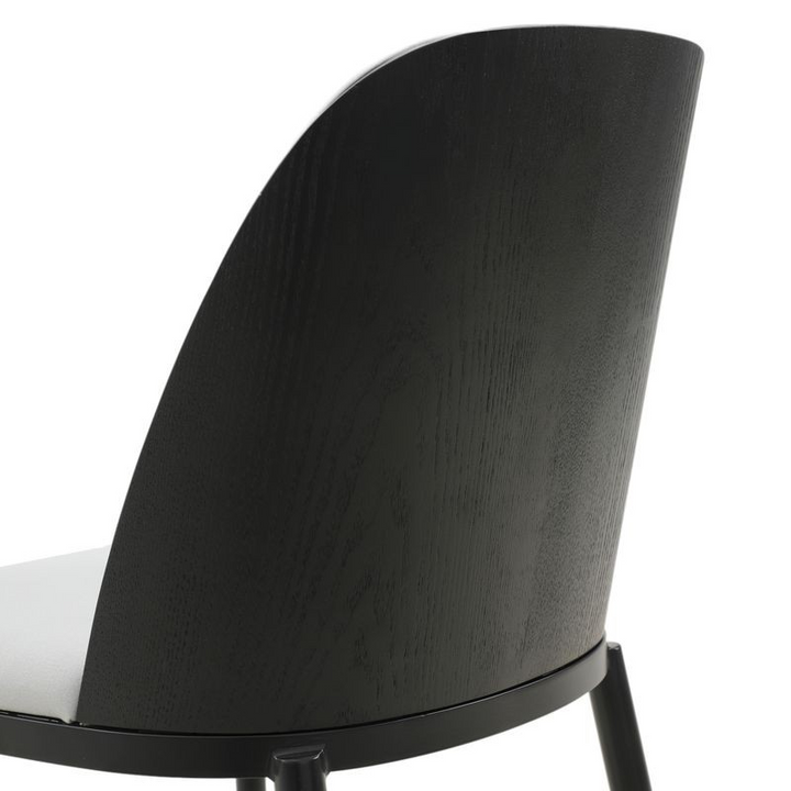 Close-up of a black chair backrest on a white background.